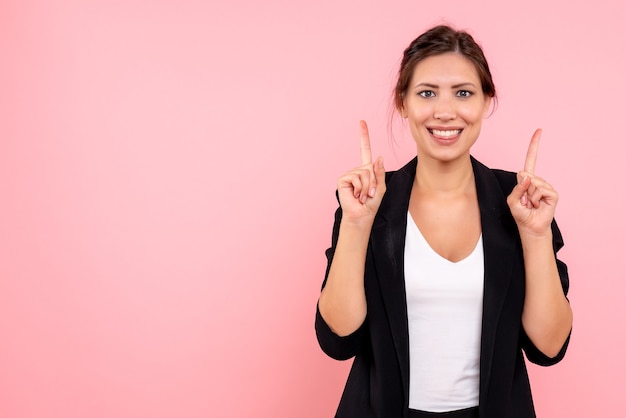 Vue de face jeune femme en veste sombre sur fond rose