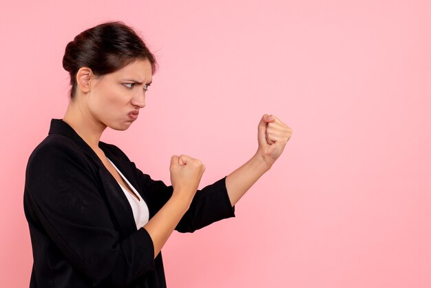 Vue de face jeune femme en veste sombre sur fond rose