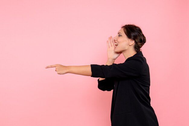 Photo gratuite vue de face jeune femme en veste sombre sur fond rose