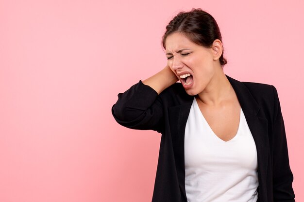 Vue de face jeune femme en veste sombre sur fond rose