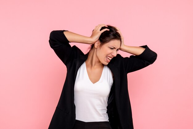 Vue de face jeune femme en veste sombre sur fond rose