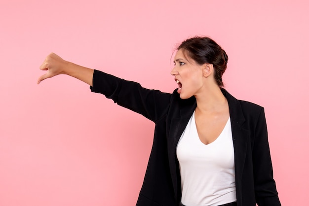 Vue de face jeune femme en veste sombre sur fond rose