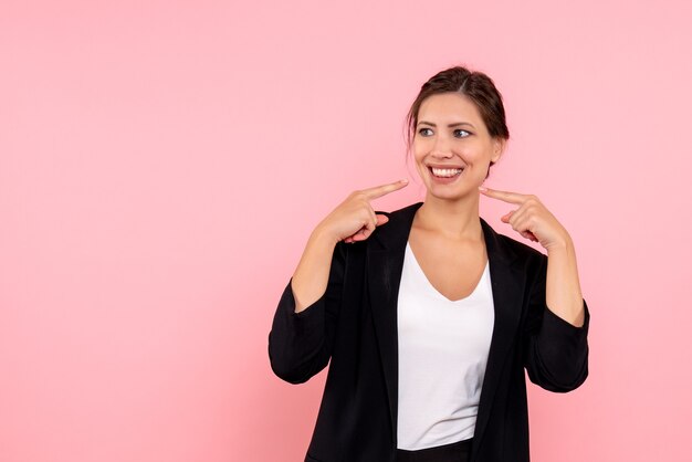 Vue de face jeune femme en veste sombre sur fond rose