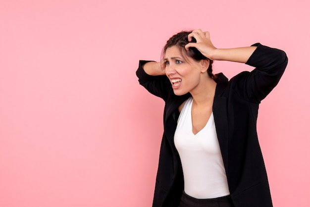 Vue de face jeune femme en veste sombre sur fond rose