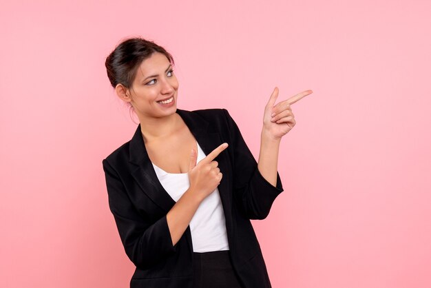 Vue de face jeune femme en veste sombre sur fond rose