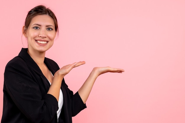 Vue de face jeune femme en veste sombre sur fond rose