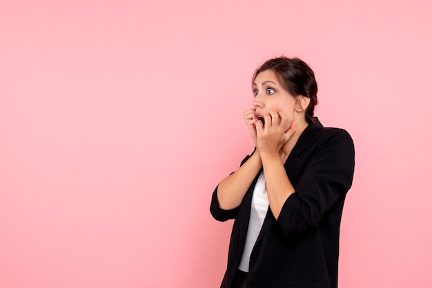 Vue de face jeune femme en veste sombre sur fond rose