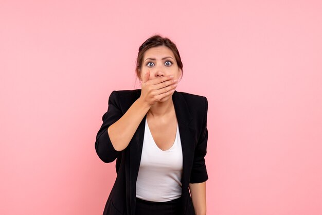 Vue de face jeune femme en veste sombre sur fond rose