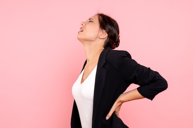 Vue de face jeune femme en veste sombre sur fond rose