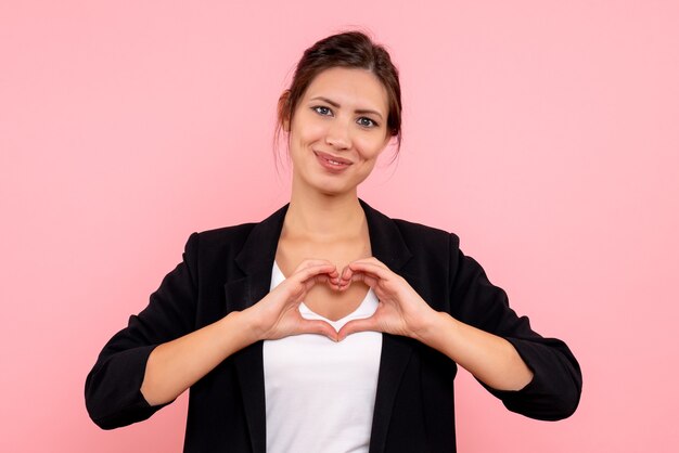 Vue de face jeune femme en veste sombre sur fond rose