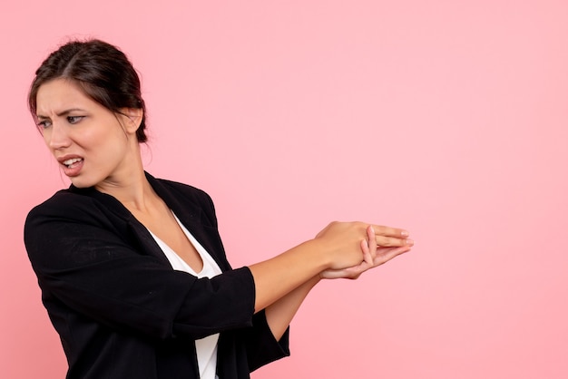 Vue de face jeune femme en veste sombre sur fond rose