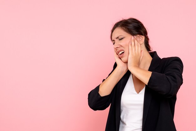 Vue de face jeune femme en veste sombre sur fond rose