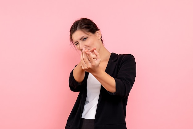 Vue de face jeune femme en veste sombre sur fond rose