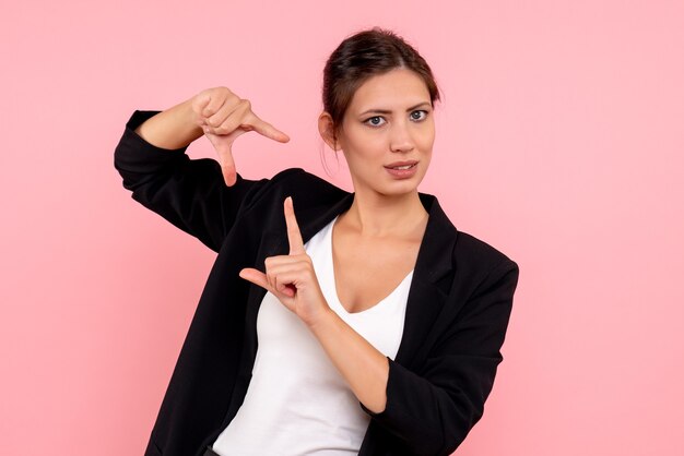 Vue de face jeune femme en veste sombre sur fond rose