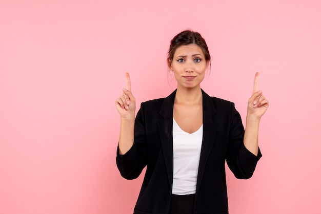 Vue de face jeune femme en veste sombre sur fond rose