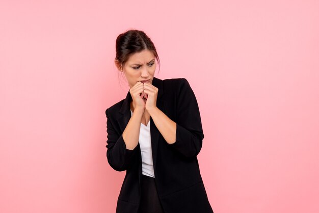 Vue de face jeune femme en veste sombre sur fond rose