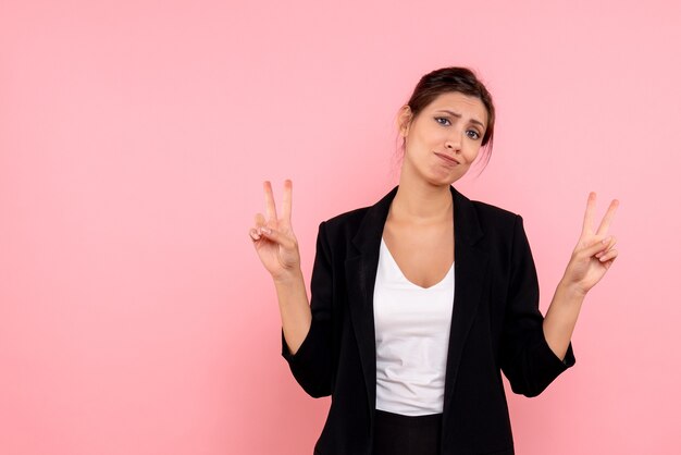 Vue de face jeune femme en veste sombre sur fond rose