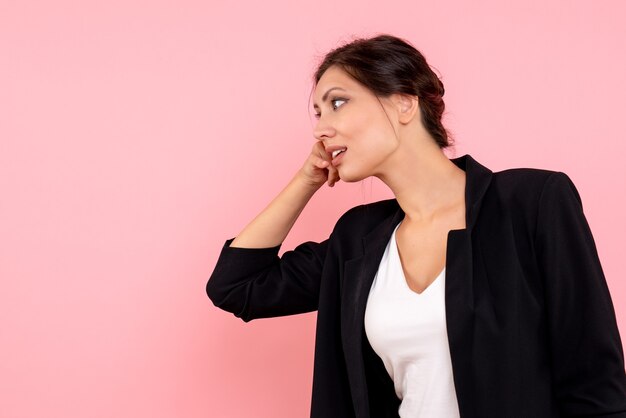 Vue de face jeune femme en veste sombre sur fond rose