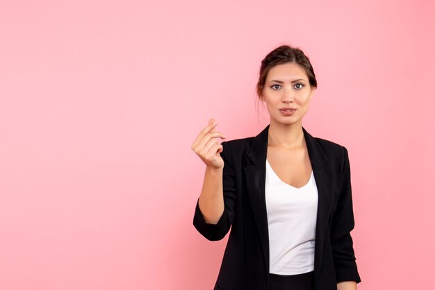 Vue de face jeune femme en veste sombre sur fond rose