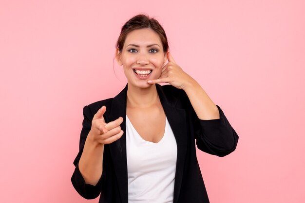 Vue de face jeune femme en veste sombre sur fond rose