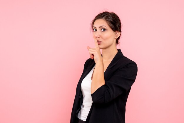 Vue de face jeune femme en veste sombre sur fond rose