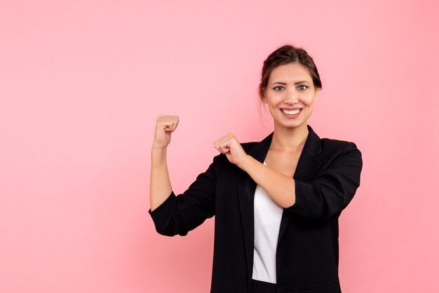 Vue de face jeune femme en veste sombre sur fond rose