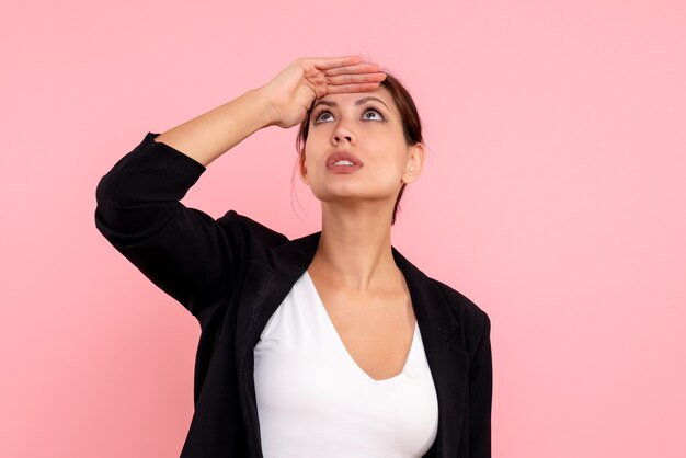 Vue de face jeune femme en veste sombre sur fond rose