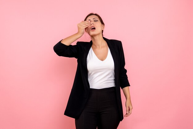 Vue de face jeune femme en veste sombre sur fond rose