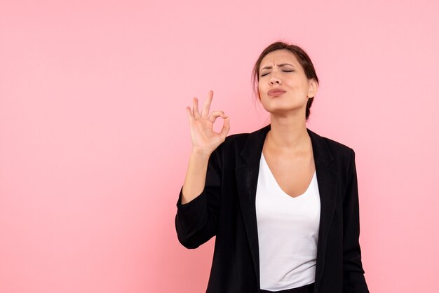 Vue de face jeune femme en veste sombre sur fond rose