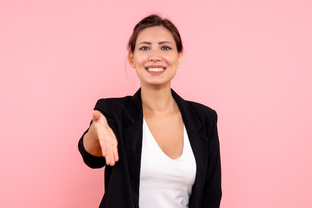 Vue de face jeune femme en veste sombre salutation sur fond rose