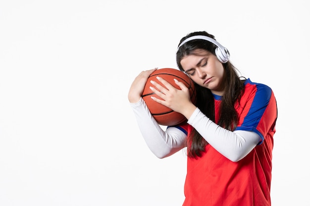 Vue de face jeune femme en vêtements de sport avec basket-ball