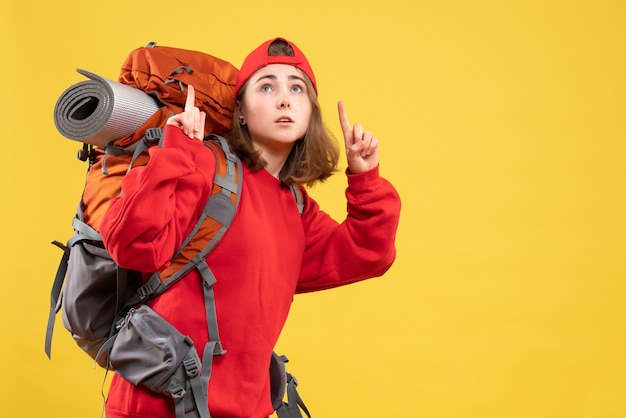 Vue de face jeune femme voyageur en sac à dos rouge pointant les doigts