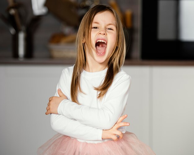 Vue de face de la jeune fille en jupe tutu avec la bouche grande ouverte