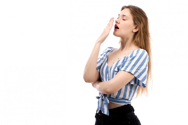 Une vue de face jeune fille séduisante en t-shirt rayé bleu-blanc portant un jean noir éternuer sur le blanc