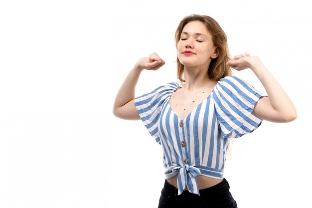 Une vue de face jeune fille séduisante en t-shirt rayé bleu-blanc portant un jean noir éternuer sur le blanc