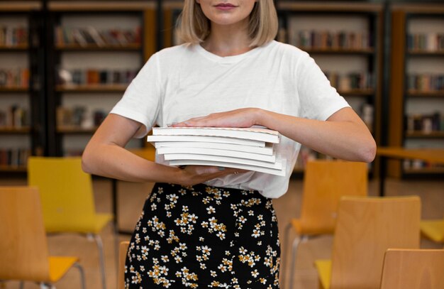 Photo gratuite vue de face jeune fille tenant des livres