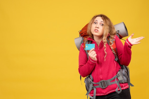 Vue de face de jeune fille voyageuse inquiète dans un masque médical tenant une carte bancaire