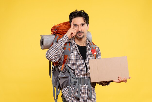 Vue de face jeune homme allant en randonnée avec sac à dos sur le fond jaune carte couleur air nature compagnie forêt voyage campus