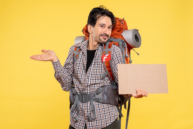 Vue de face jeune homme allant en randonnée avec sac à dos sur le fond jaune carte couleur nature compagnie forêt voyage campus air