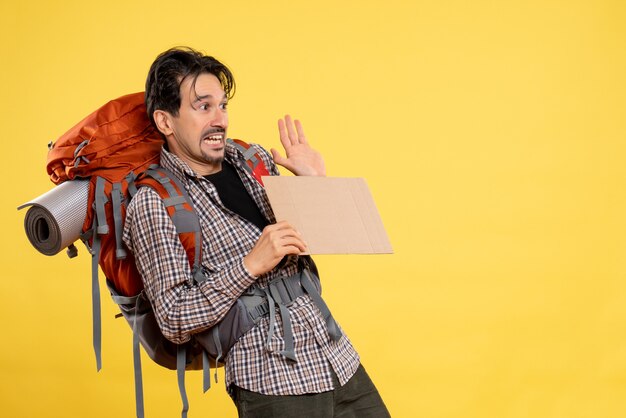 Vue de face jeune homme allant en randonnée avec sac à dos sur fond jaune couleur voyage en avion nature campus forêt émotion carte de l'entreprise