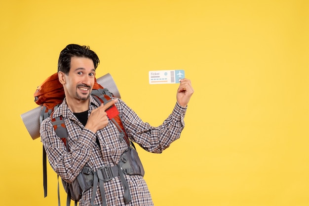 Photo gratuite vue de face jeune homme allant en randonnée avec sac à dos tenant un billet d'avion sur fond jaune carte couleur voyage campus air forêt nature