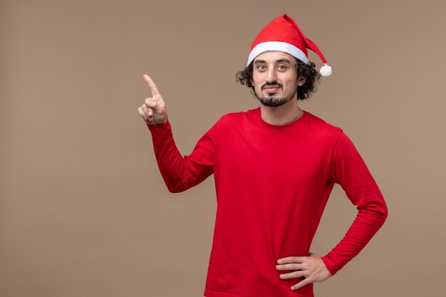 Vue de face jeune homme au visage calme sur le fond marron vacances Noël émotion