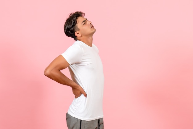 Vue De Face Jeune Homme Ayant Mal Au Dos Sur Fond Rose Couleur Modèle émotion Mâle