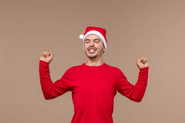 Vue de face jeune homme bâillant sur fond marron vacances de Noël émotion mâle