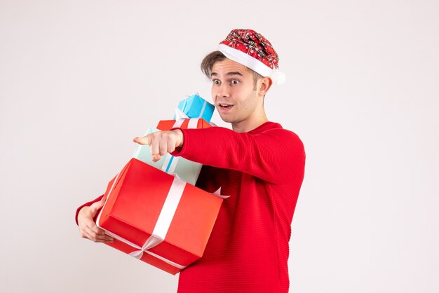 Photo gratuite vue de face jeune homme avec bonnet de noel debout sur l'espace de copie de fond blanc