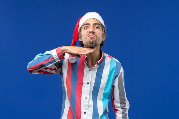 Vue de face jeune homme avec bonnet de Noël rouge, émotion de Noël masculine