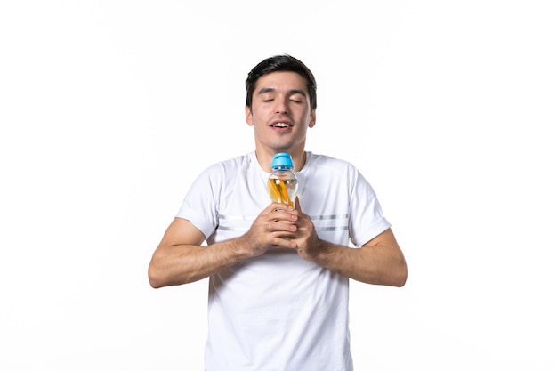 Vue de face jeune homme avec une bouteille de limonade sur fond blanc jus de peau liquide de fruits eau humaine boisson