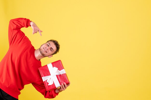 Vue de face jeune homme avec cadeau de Noël