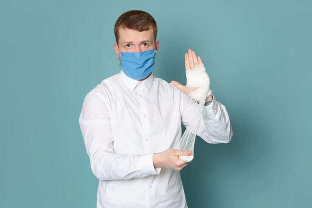 Une vue de face jeune homme en chemise blanche avec un bandage blanc sur l'espace bleu