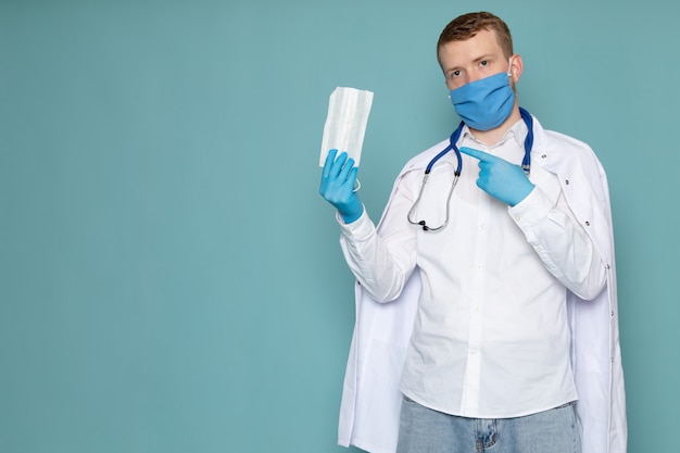 Une vue de face jeune homme en chemise blanche et gants bleus sur l'espace bleu